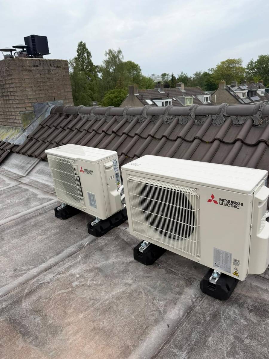 Twee Mitsubishi Electric buitendelen op rubberen dakvoeten op een plat dak